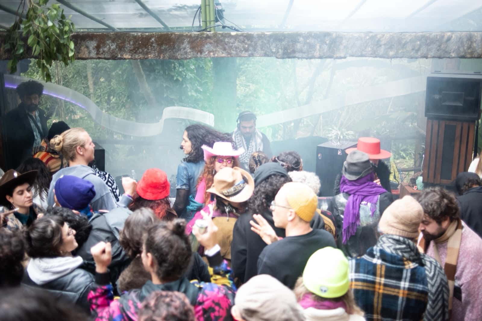 Roda em volta da cabine de DJ sob a estufa, fumaça e chapéus