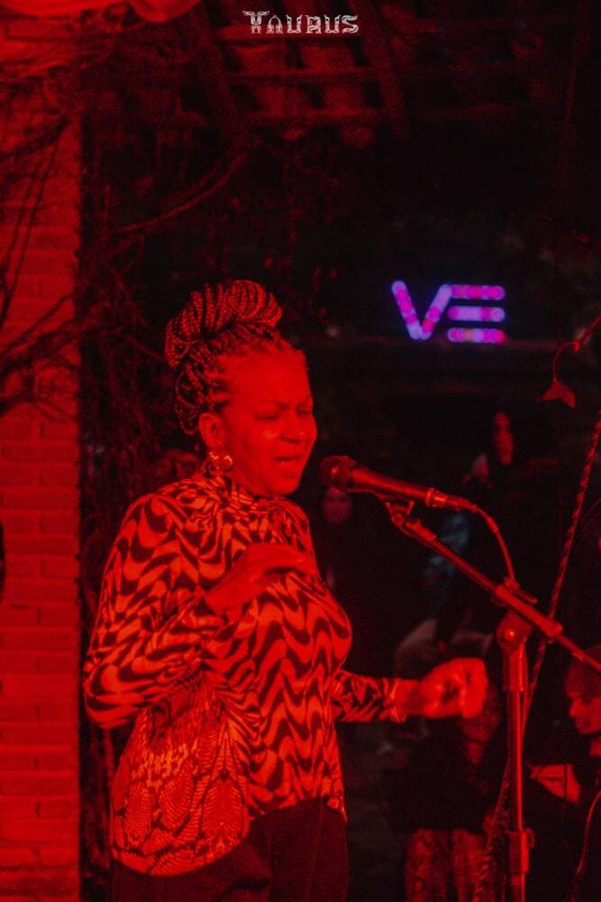 Cantora ao microfone iluminada de vermelho