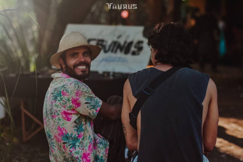 Veluder de camisa florida no bar, sorrindo